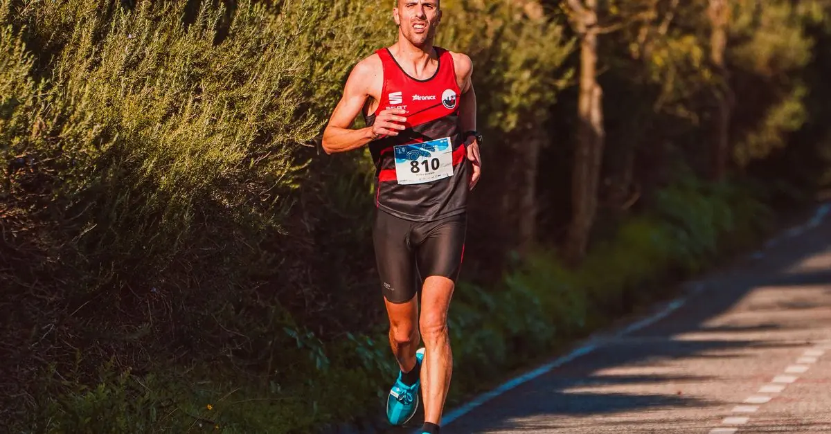 10kmロードレース中に腕時計で1kmラップを確認するランナー