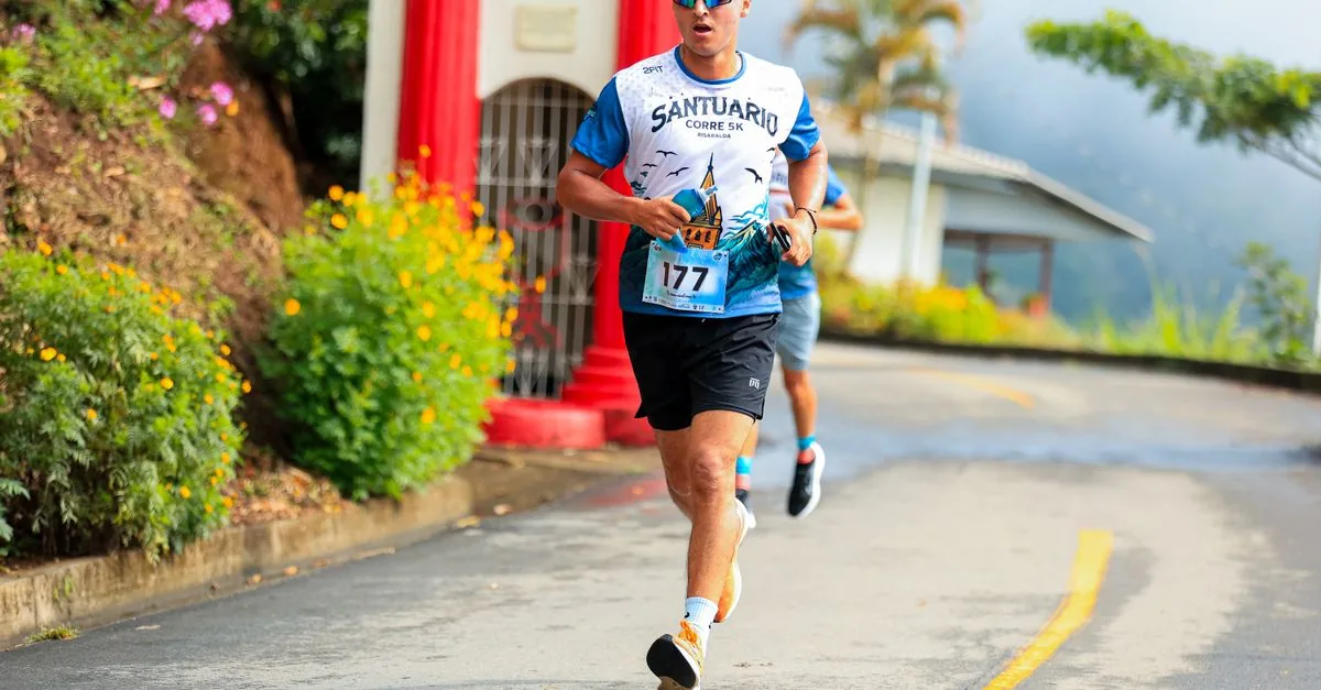 陸上トラックでGPSウォッチを確認しながら5kmタイムトライアルを走る市民ランナー