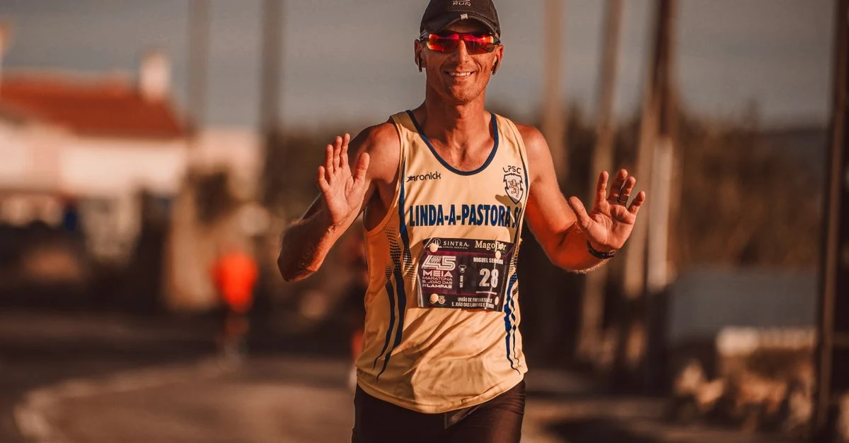 深めのランニングキャップを着用して河川敷を走るランナー