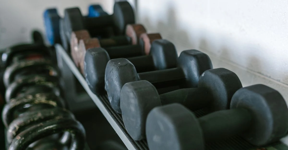 ダンベルとケトルベルを並べて選ぶランナー