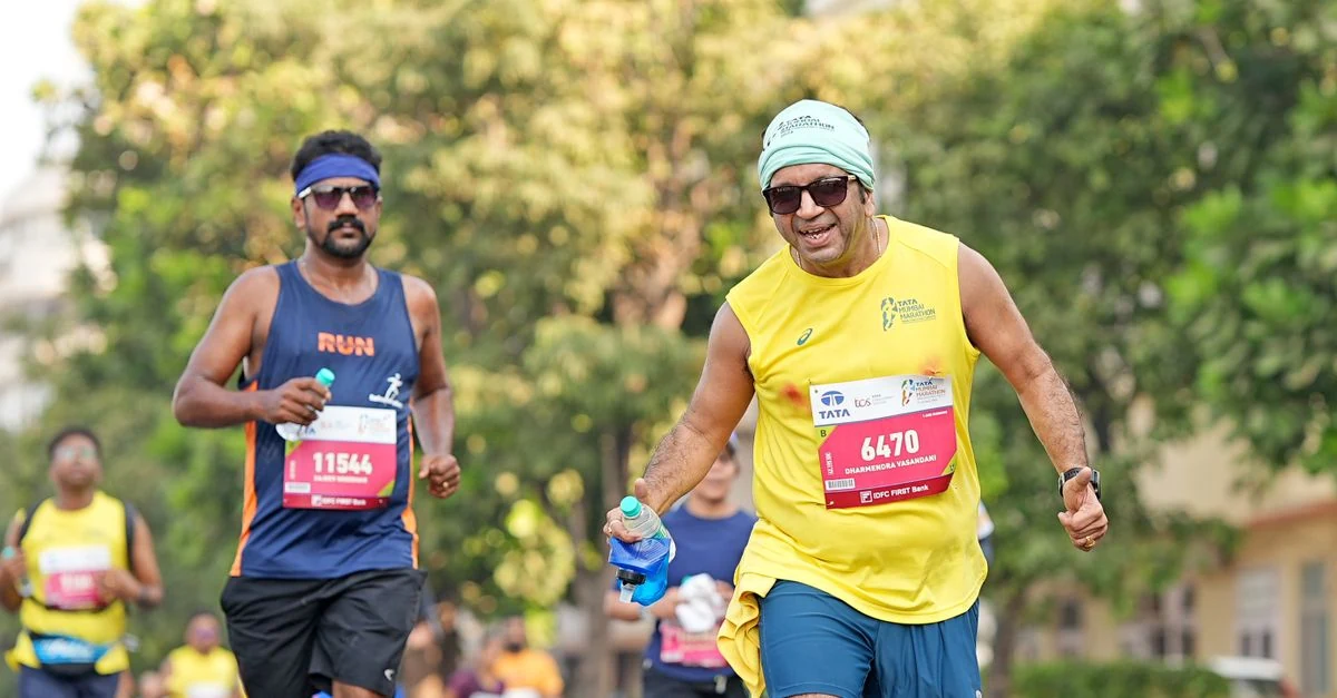 マラソンを走り時計でタイムを確認する60代のシニアランナー