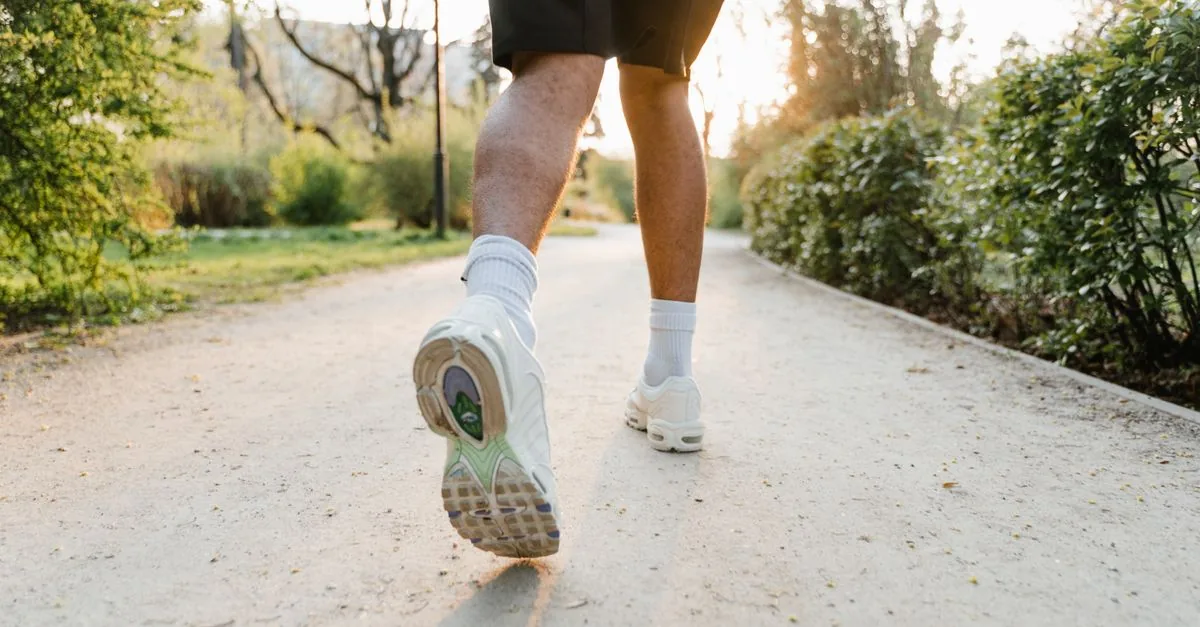 60代のランナーがクッション性と安定性を確かめながらランニングシューズを選ぶ様子