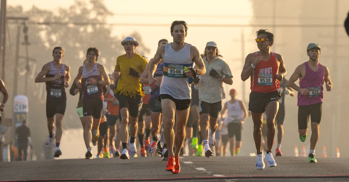 屋外でランニング後にすねの内側を確認するランナー
